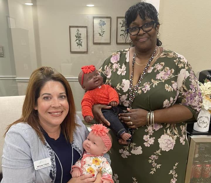 Arabella of Red Oak | Two caregivers holding baby dolls for The Grand Baby Project