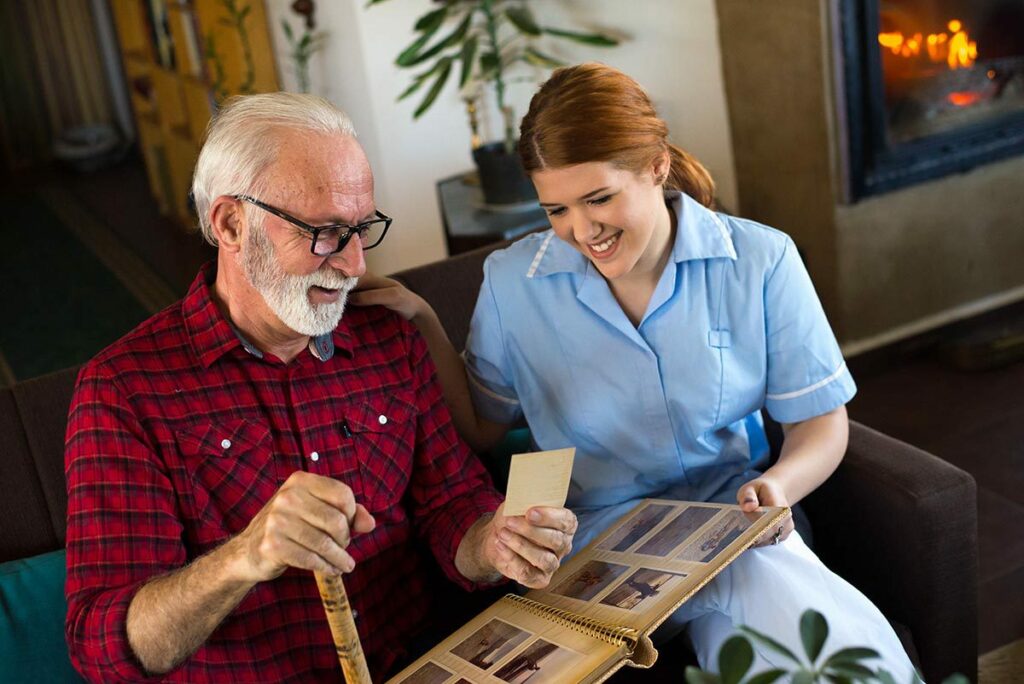 Ledgestone | Senior man with caregiver looking at family photos