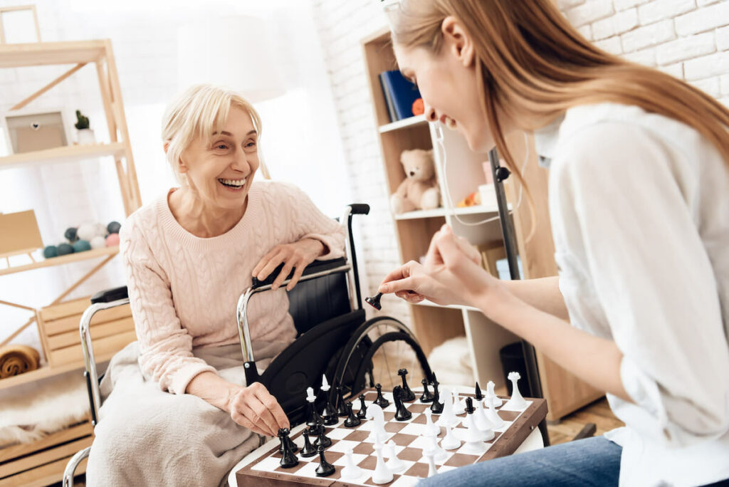 The Ridglea | Senior woman and her caregiver playing a game of chess