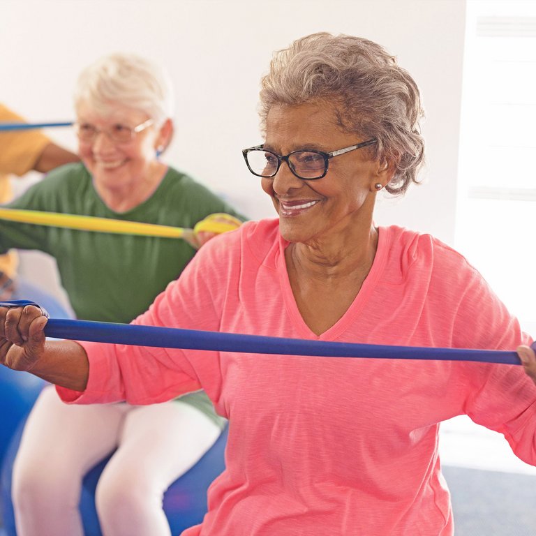 Civitas Senior Living | Senior woman doing band exercise on an exercises ball