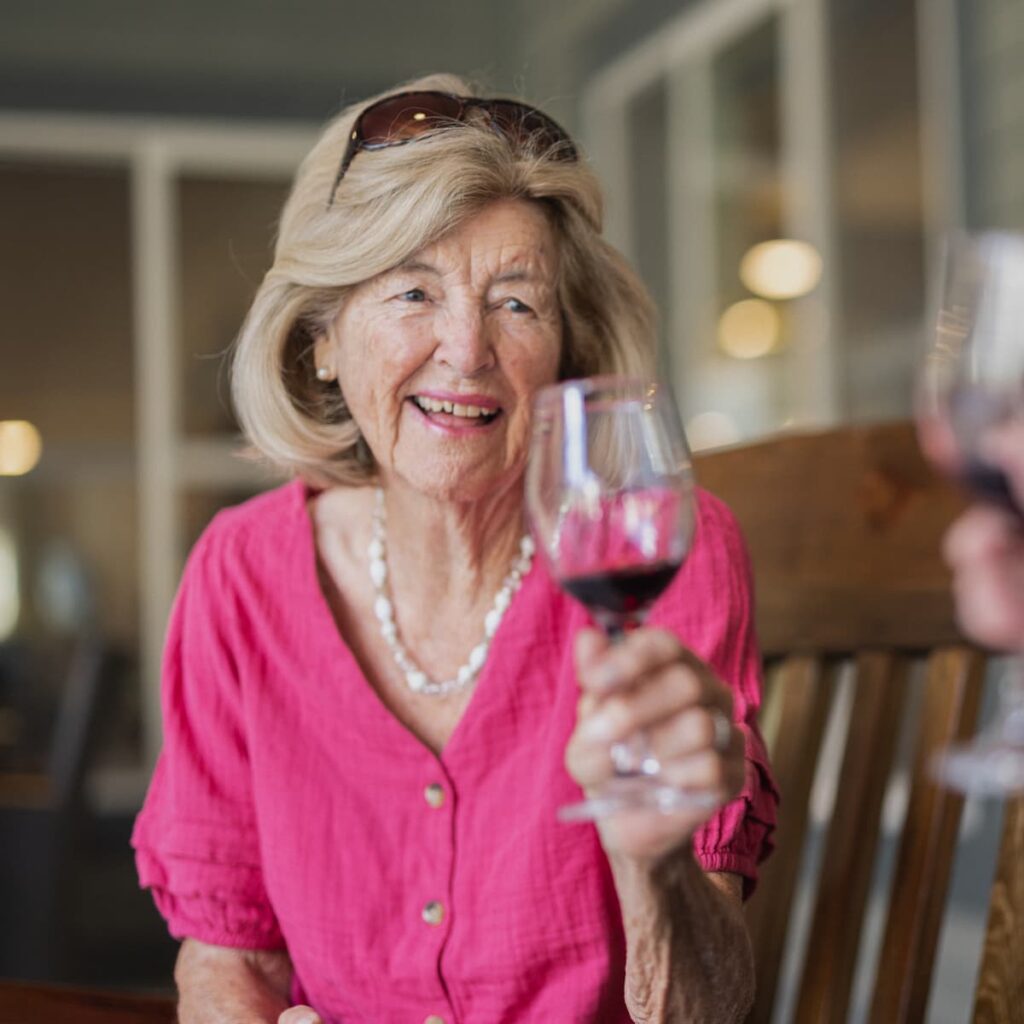 Alexis Point of Wimberley | Senior woman enjoying a glass of wine on the porch