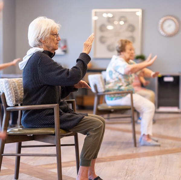 Arabella of Athens | Senior woman doing chair exercises in class