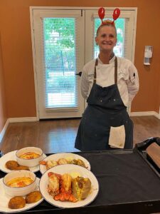 Arabella of Athens | Chef smiling and standing proudly by the food she coooked