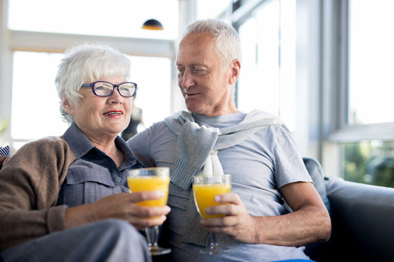 Arabella of Kilgore | Senior couple relaxing on couch with orange juice