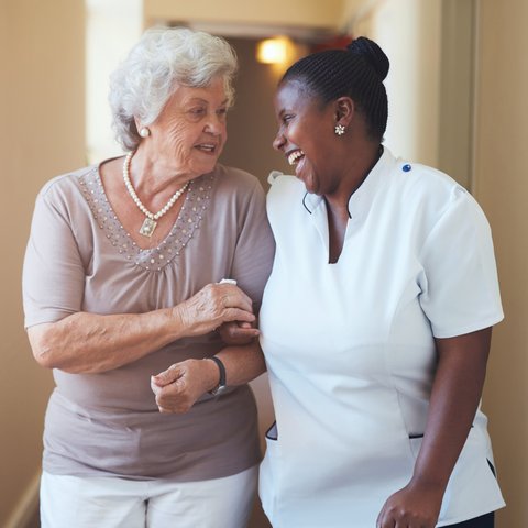 Arabella of Longview | Senior woman walking arm in arm with her caregiver