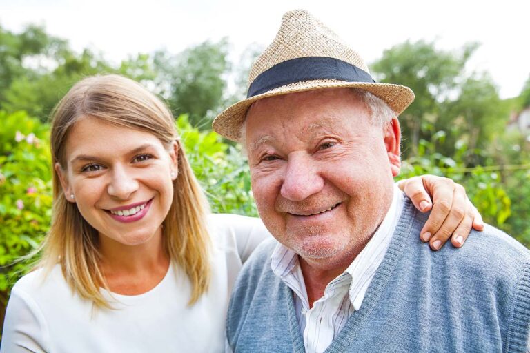 Arabella of Longview | Smiling senior man standing with his caregiver