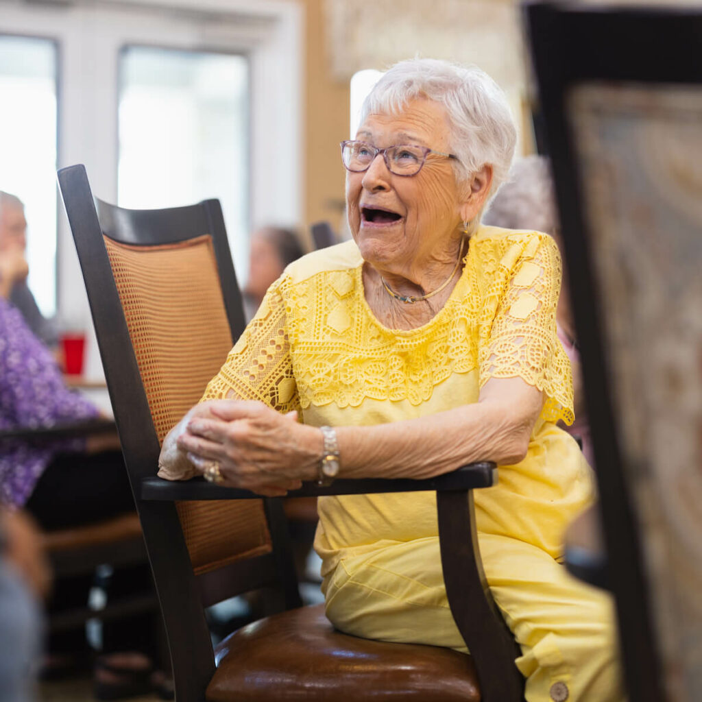 Arabella of Red Oak | Senior woman smiling in dining hall