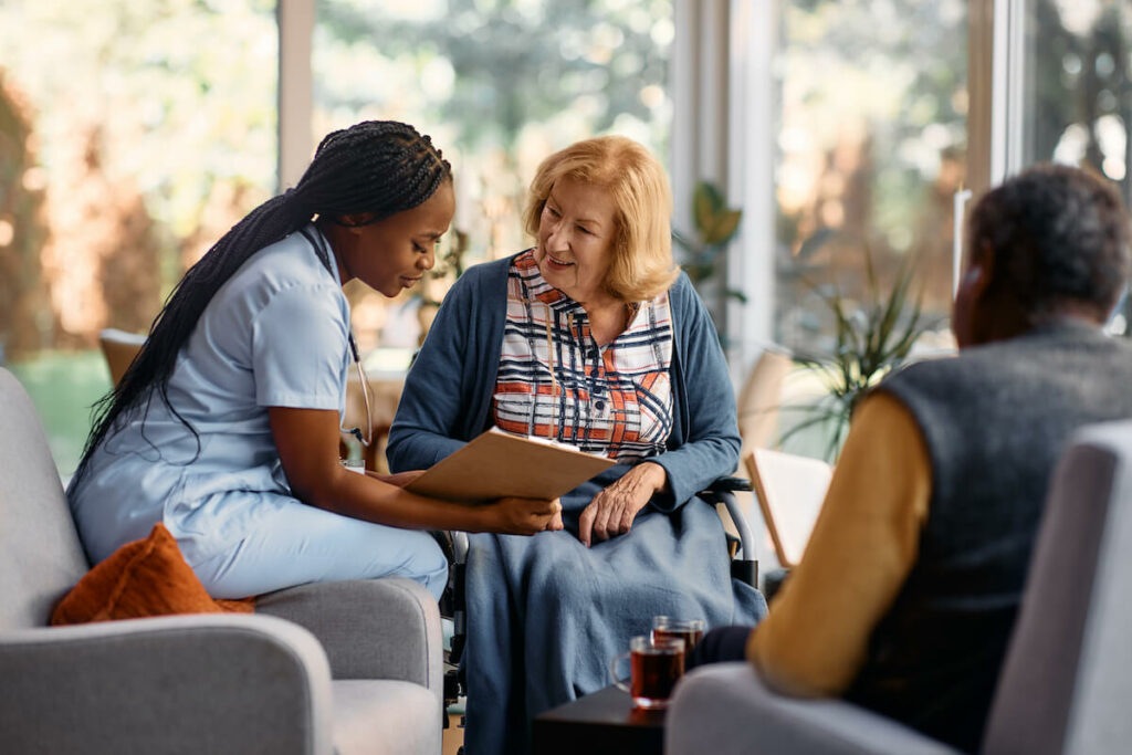 Arabella of Red Oak | Senior woman talking with her caregiver and looking at important information