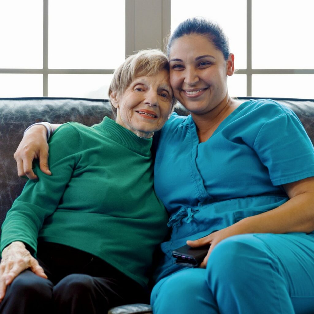 Ariel Pointe of Sachse | Senior woman sitting on the couch with caregiver