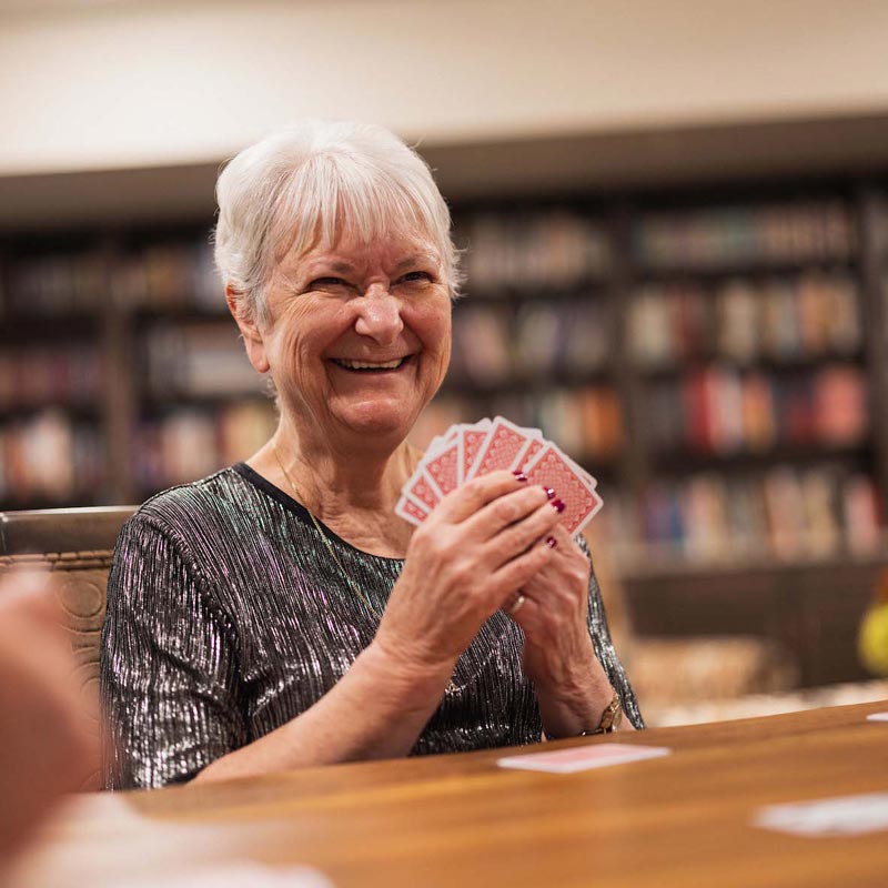 Autumn Wind | Happy senior woman playing cards