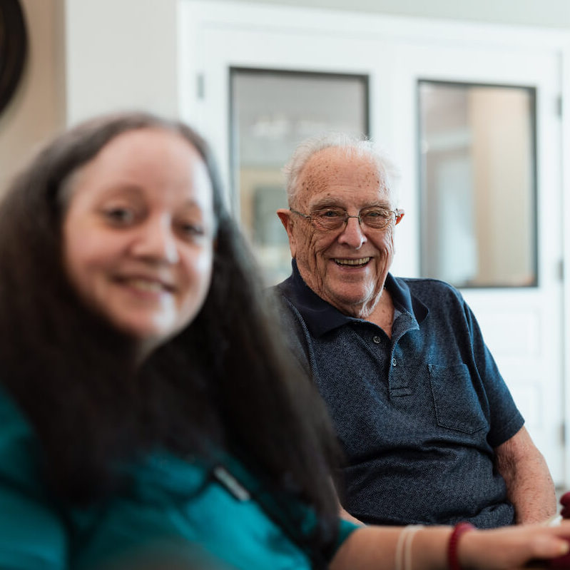 Cambridge Court | Smiling senior man with caregiver at event