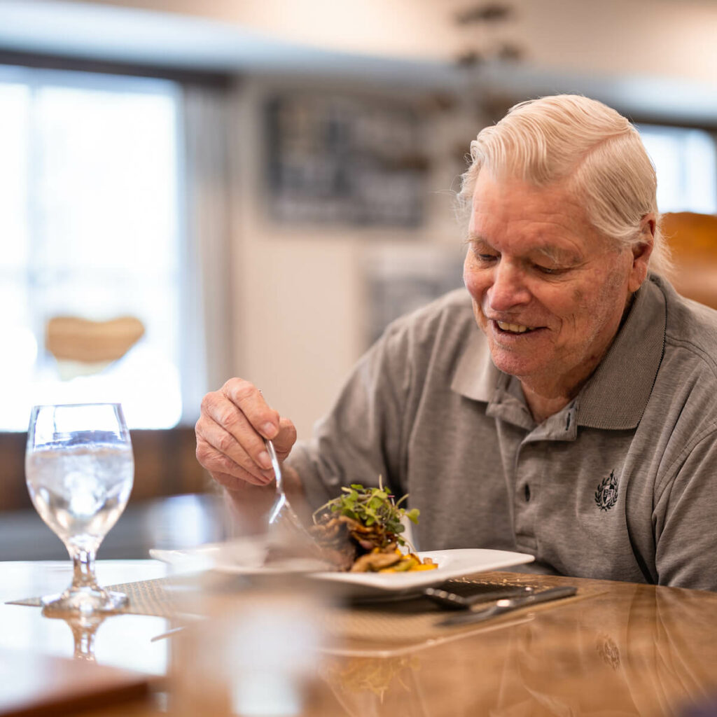 Cambridge Court | Senior man eating chef-prepared meal in dining hall