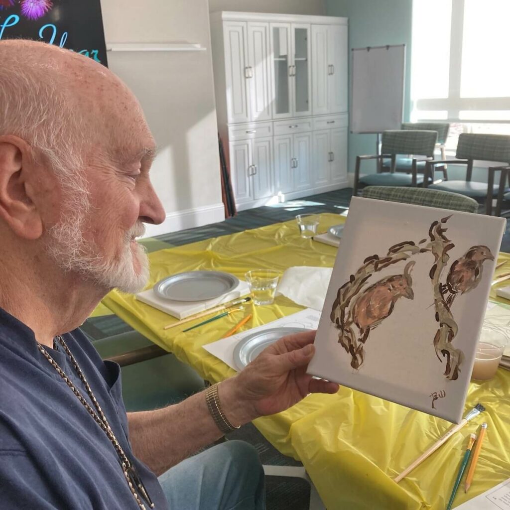 Cambridge Court | Senior man sharing his painting during art class