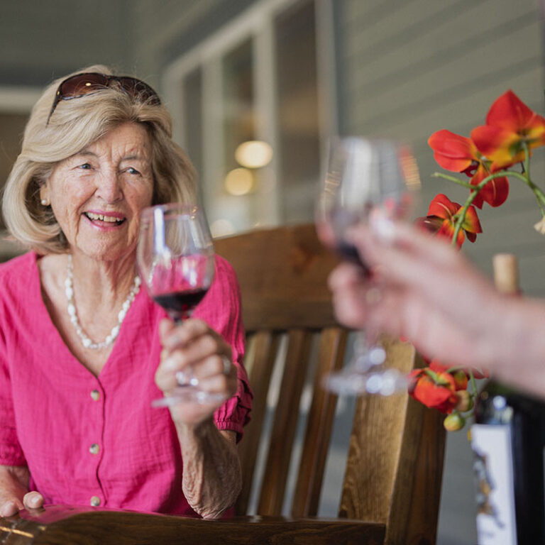 Cambridge Court | Senior woman toasting with glass of wine