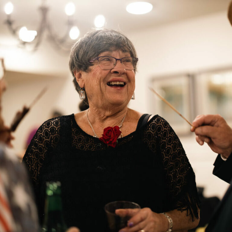 Cambridge Court | Senior woman smiling at a fun event