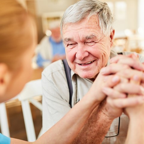 Dancing River | Senior man holding hands with caregiver