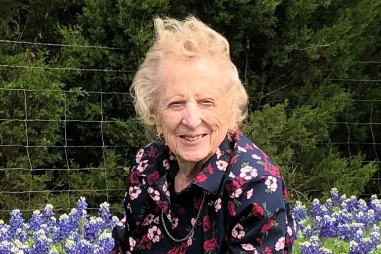 Double Creek | Senior woman sitting in a field of flowers