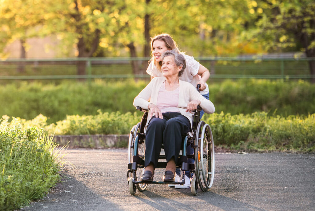 Civitas Senior Living | Senior with caregiver enjoying the sunshine outside