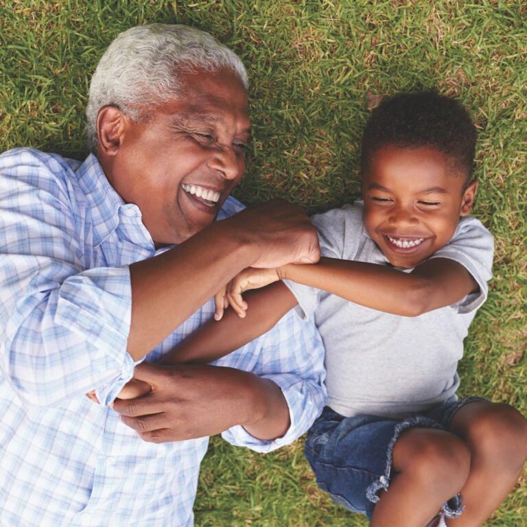 Harvest of Aledo | Senior man and grandson playing outdoors on grass