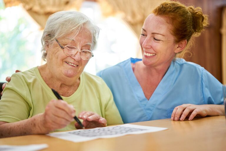 Harvest of Aledo | Senior woman with caregiver doing crossword puzzle.