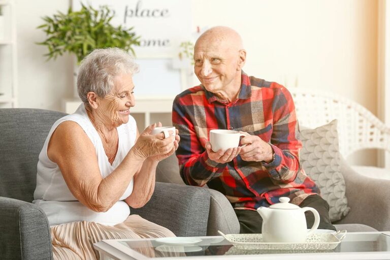 Harvest of Roanoke | Happy senior couple drinking tea on couch