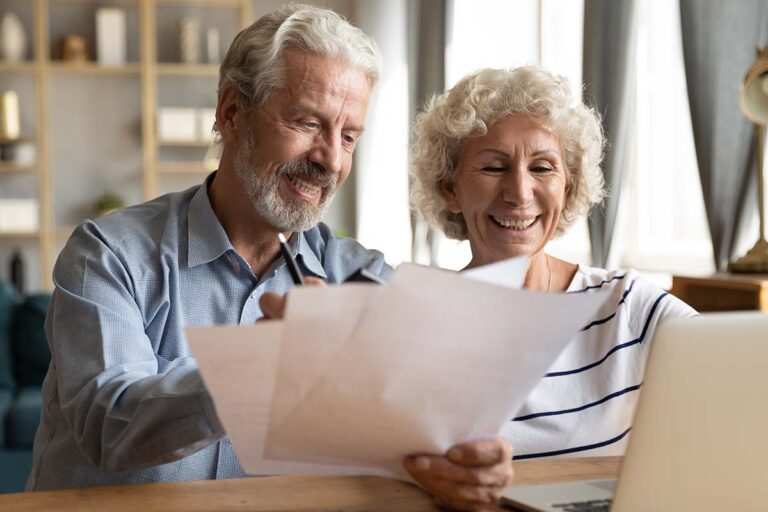 Civitas Senior Living | Senior couple use online banking on laptop planning family budget
