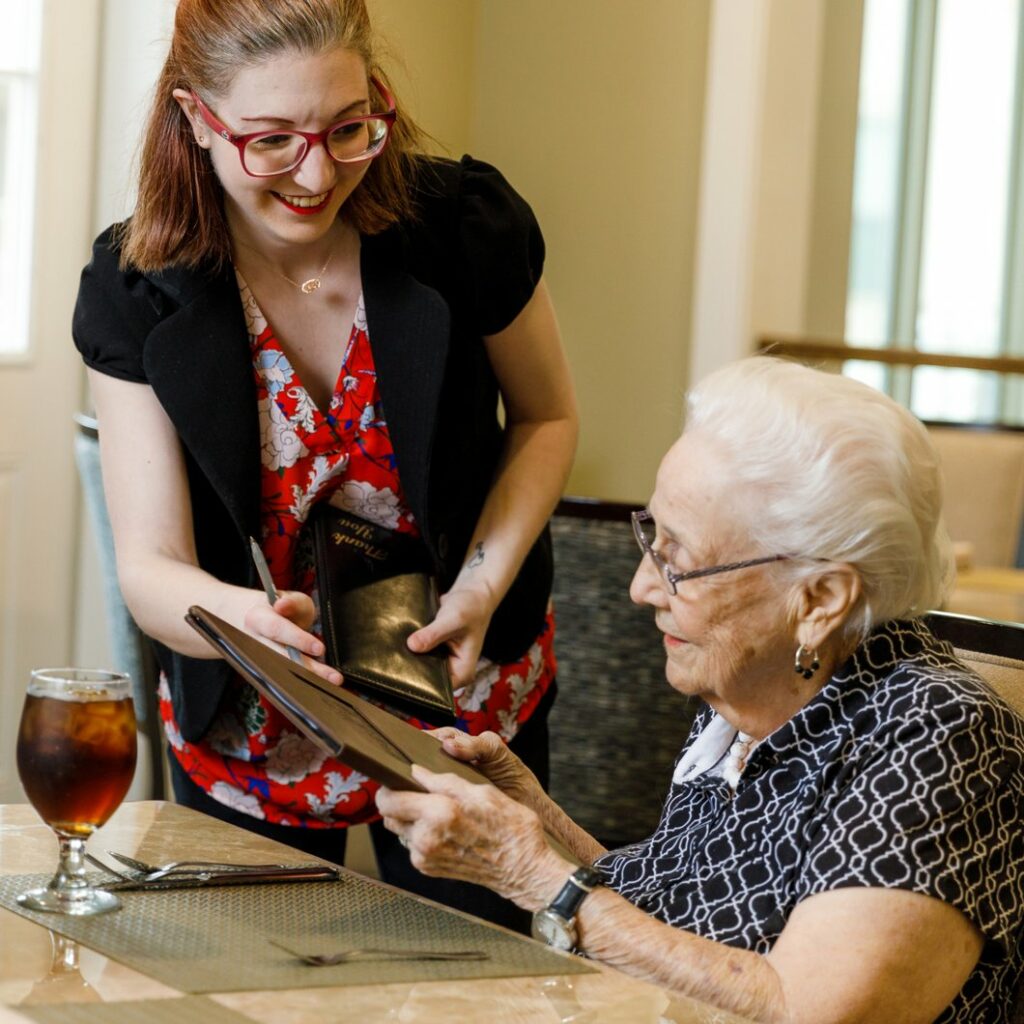 Ledgestone Senior Living | Senior woman handing menu to waitress