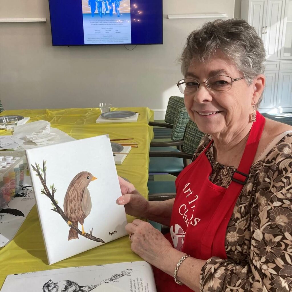 Ledgestone Senior Living | Senior woman holding up her painting