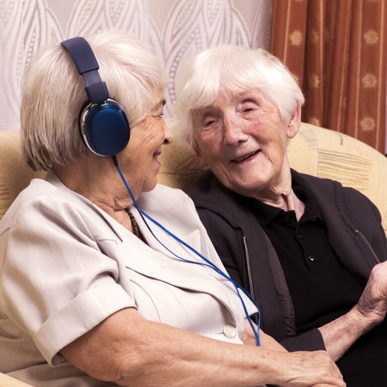 Legacy Oaks of South Austin | Senior women listening on headphones