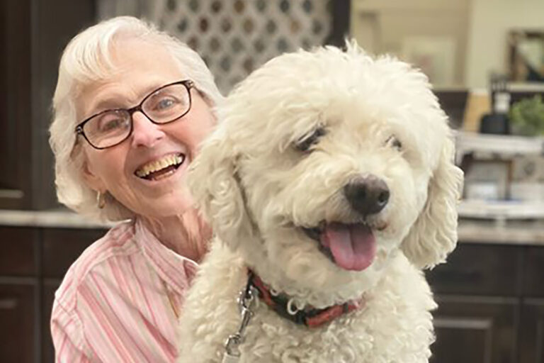 Civitas Senior Living | Happy senior smiling with smiling white, fluffy dog
