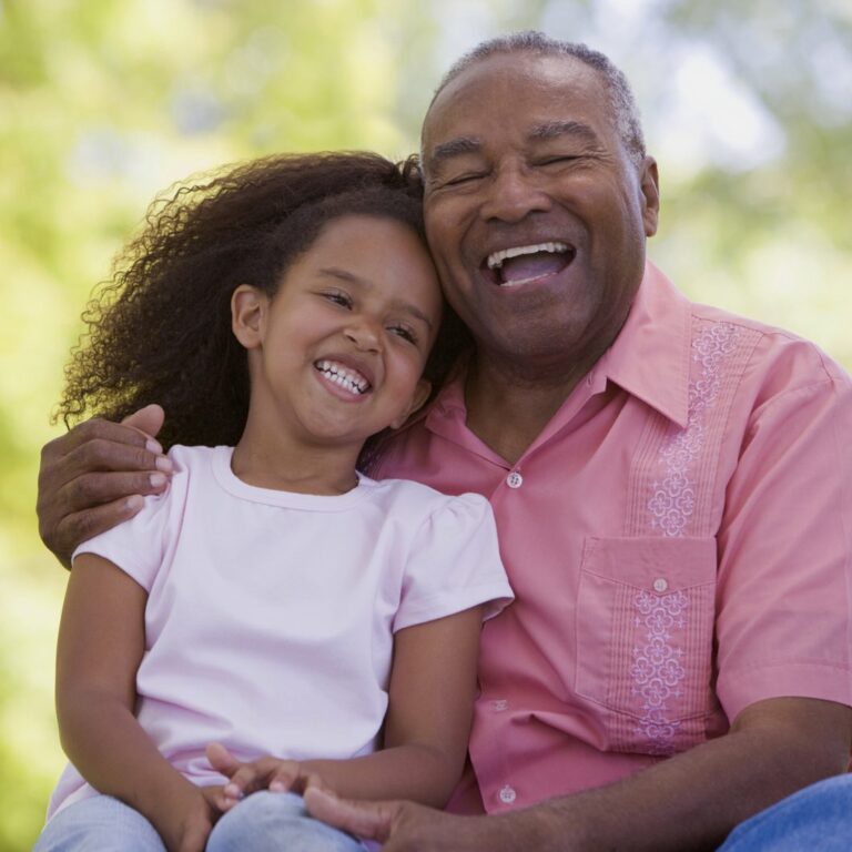 Long Creek | Senior man smiling with granddaughter outdoors