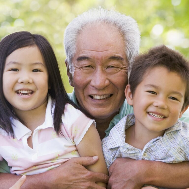 Long Creek | Senior man holding grandchildren and smiling