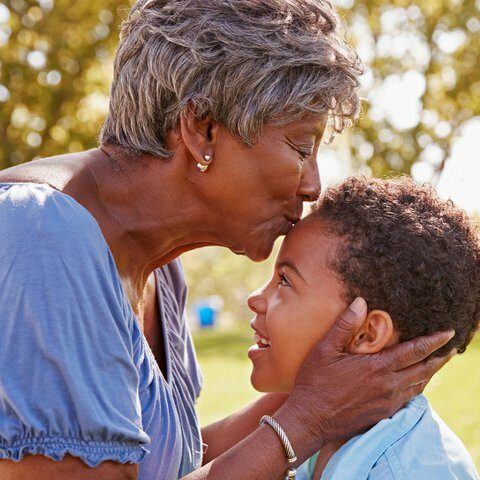 Stone Creek of Copperfield | Senior woman kissing grandson's forehead