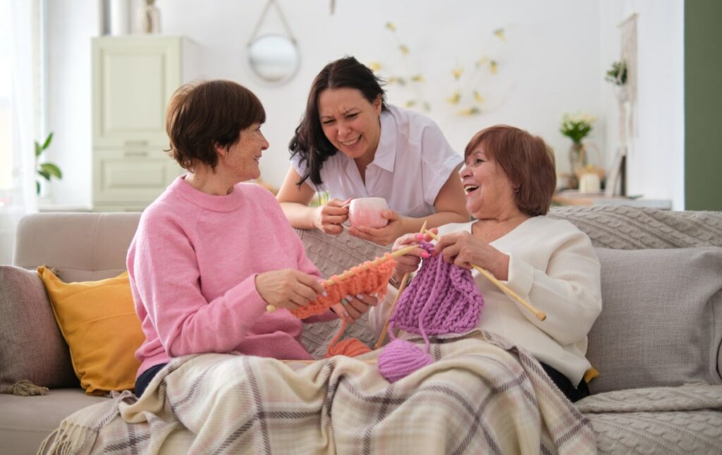 StoneCreek of Copperfield | Seniors knitting and talking on the couch