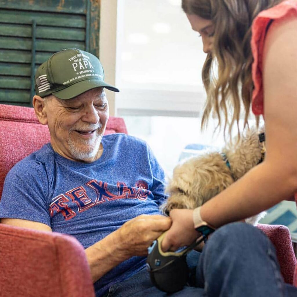 Stonecreek of Copperfield | Senior memory care residents petting dogs
