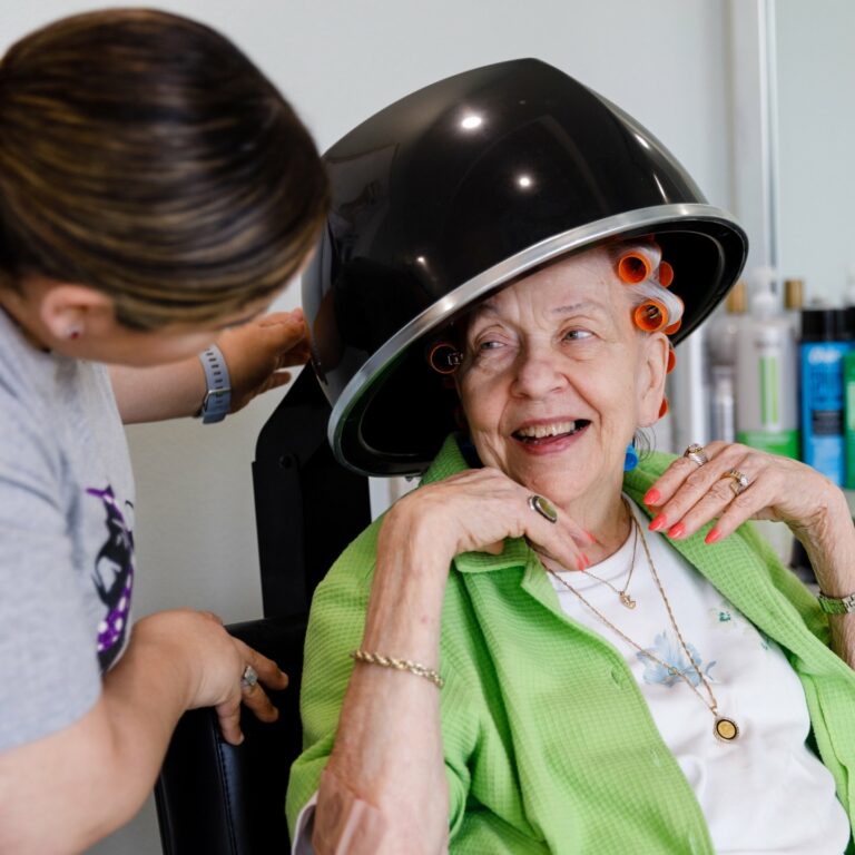 StoneCreek of Flying Horse | Senior woman laughing with associate at salon