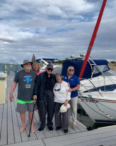 StoneCreek of Flying Horse | Senior resident with boat crew next to sailboat