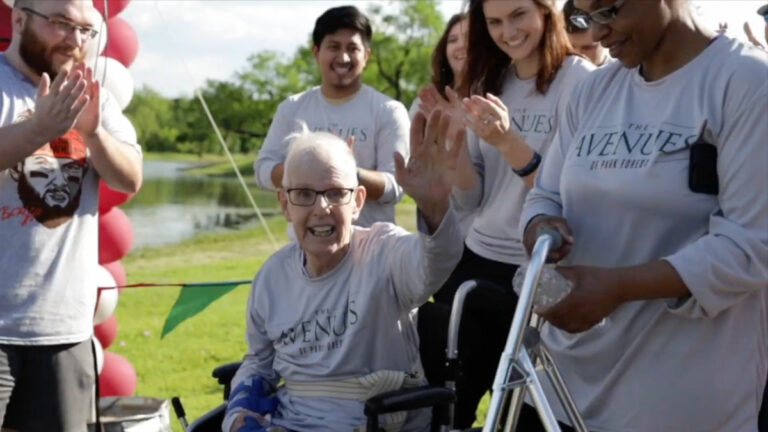 StoneCreek of North Richland Hills | Senior man in wheelchair surrounded by happy cheerful caregivers