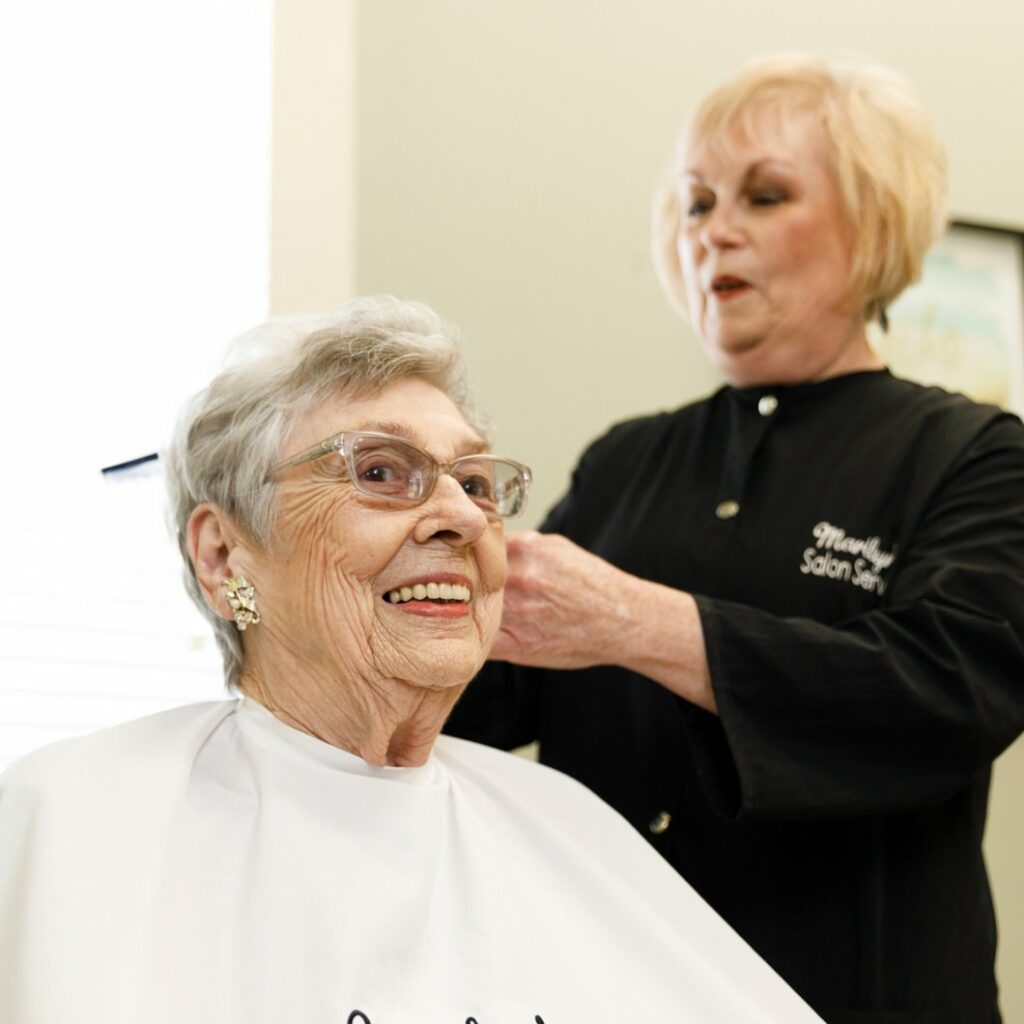 StoneCreek of North Richland Hills | Senior woman getting a haircut by a hairdresser