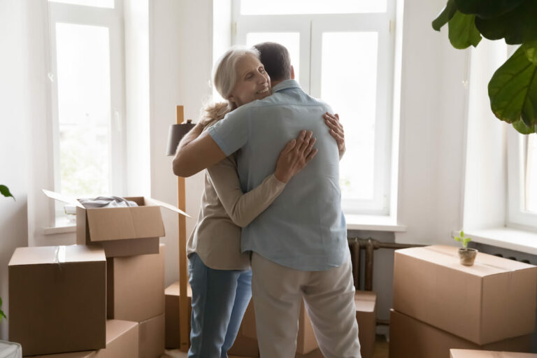 Civitas Senior Living | Senior woman hugging her son in a room surrounded by boxes