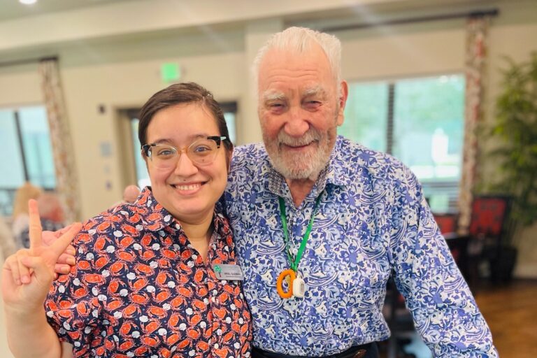 Tech Ridge Oaks | Senior living community resident smiling with a team member showing the peace sign