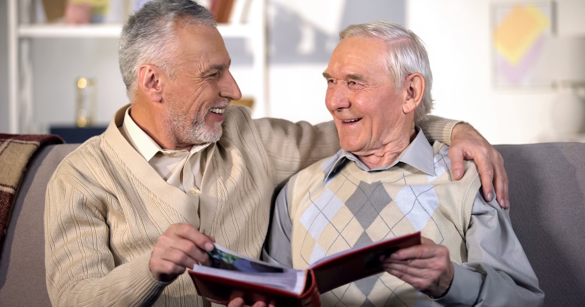 Tech Ridge Oaks | Senior man looking through photos with a loved one.