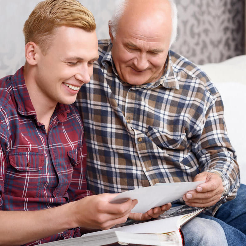 The Avenues of Fort Bend | Senior man and his grandson looking through a photo album