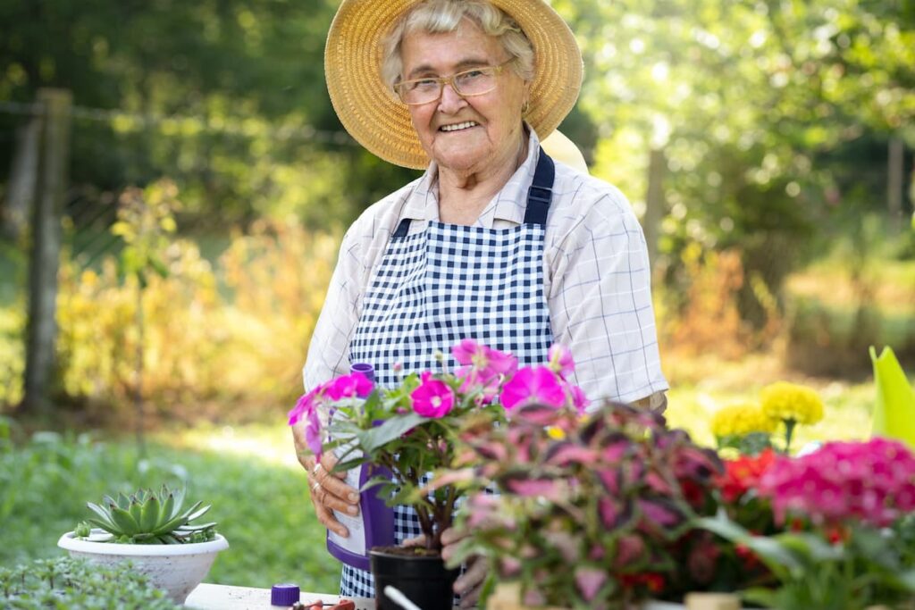 The Avenues of Fort Bend | Memory care Richmond, TX - senior woman gardening outside with flowers
