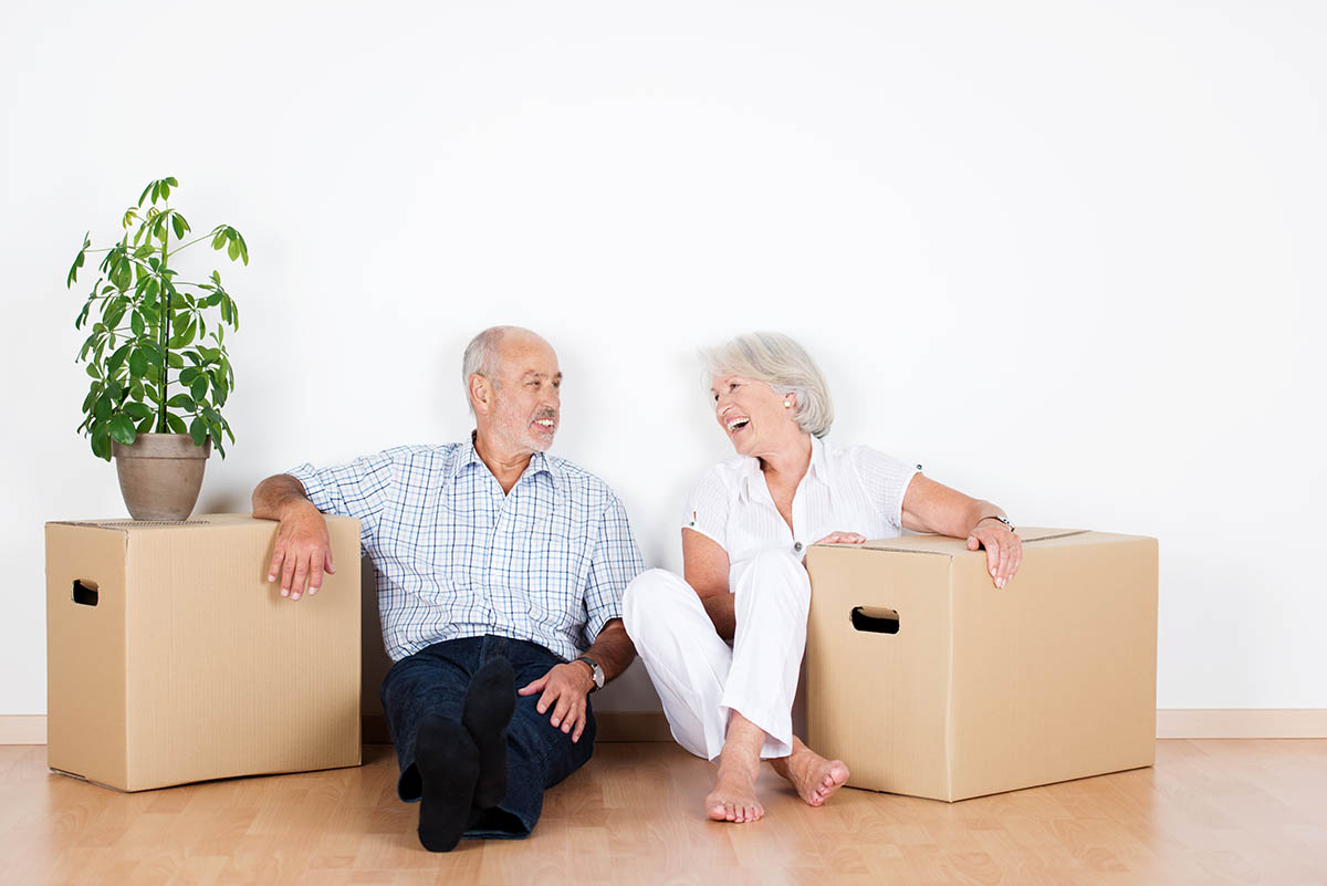 The Bluffs of Flagstaff | Seniors sitting on the ground with moving boxes and a plant
