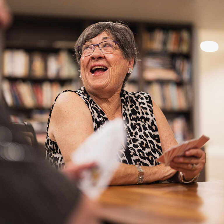 The Bluffs of Flagstaff | Senior woman laughing and playing cards