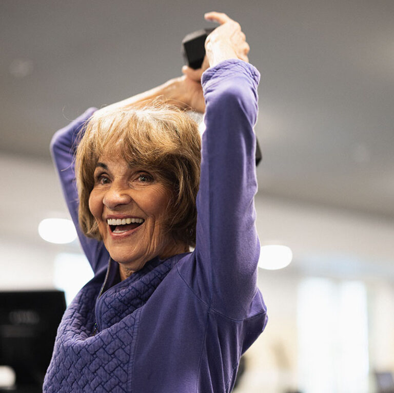 The Bluffs of Flagstaff | Senior woman working out triceps and smiling