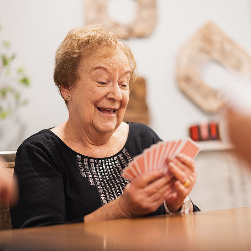 The Bluffs of Flagstaff | Senior woman looking at hand of cards