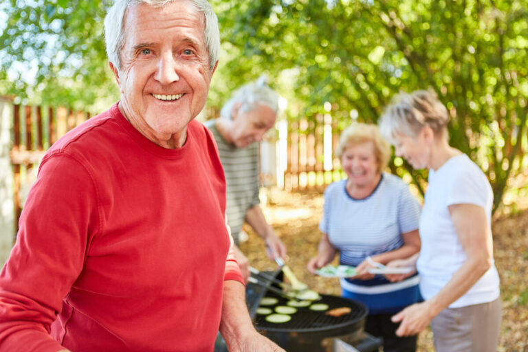 The Brooks of Cibolo | Group of happy seniors barbecuing outside