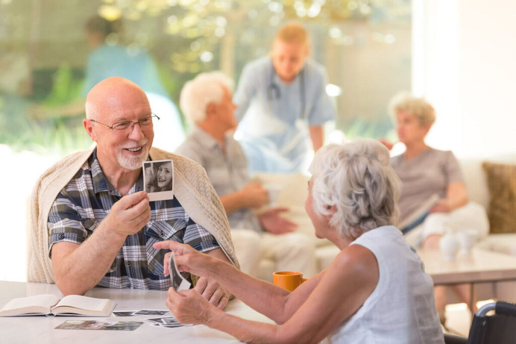 The Grand Senior Living | Senior man showing pictures to a friend